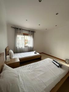 费雷尔Ocean Guesthouse Baleal的一间卧室设有两张床和窗户。