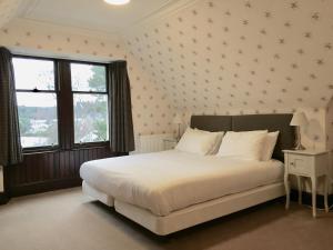 卡布里奇Dalrachney Lodge的卧室设有一张白色大床和一扇窗户。