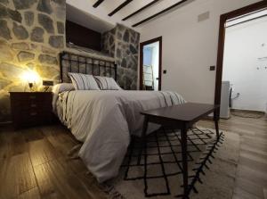 Albanchez de ÚbedaCasa Fina的一间卧室设有一张带石墙的大床