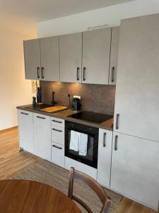 沃尔姆斯Traumhaft helle Wohnung mit Sonnenterrasse的厨房配有白色橱柜和炉灶烤箱。