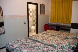 奥尔泰莱蒂齐亚酒店的酒店客房设有两张床和卫生间。