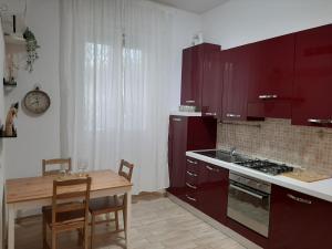 佛罗伦萨Appartamento vicino aeroporto的厨房配有红色橱柜和桌椅