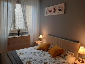 佛罗伦萨Appartamento vicino aeroporto的一间卧室配有一张带两盏灯的床和两扇窗户。