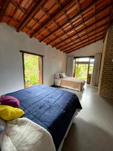 帕尔梅拉斯Casa Mirante do Capão的一间大卧室,配有两张床和大窗户