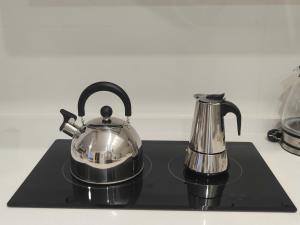 马拉加M&D Centro Málaga的茶壶和黑盘上的咖啡壶