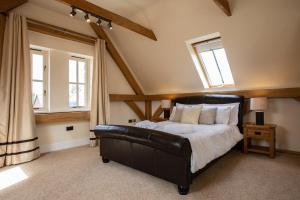 雅茅斯The Old Barn, Newclose Farm的一间卧室设有黑色皮革床和2个窗户。