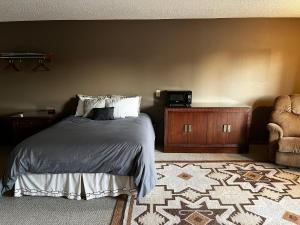 Beaver CityFurnas County Lodging的一间卧室配有一张床、一张桌子和一把椅子