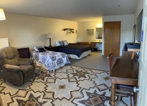 Beaver CityFurnas County Lodging的配有一张床和一把椅子的酒店客房