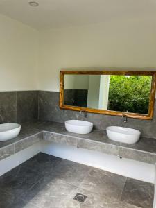 邦劳Red Picnic Hostel的一间带三个水槽和镜子的浴室