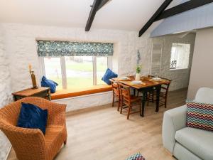 滕比Bluebell Cottage的客厅配有桌椅和窗户。