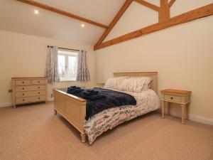 普雷斯顿Meadowside Barn的一间卧室配有一张床、一个梳妆台和一扇窗户。