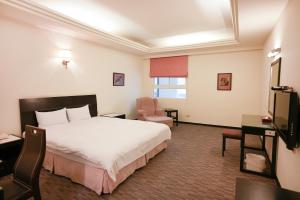 台中市禾康商务旅馆的配有一张床和一把椅子的酒店客房