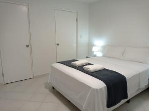 巴拿马城Doña Nancy的白色卧室配有带2条毛巾的床
