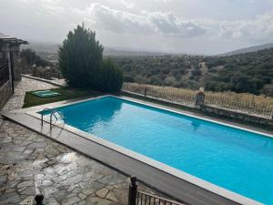AvramiliáPetrines Villes Avramilias的大型蓝色游泳池,享有山景