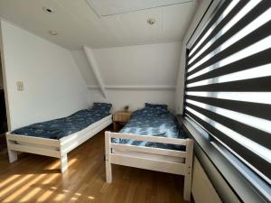 斯哈亨Vakantiehuis centrum Schagen nabij zee / strand的小型客房 - 带2张床和窗户