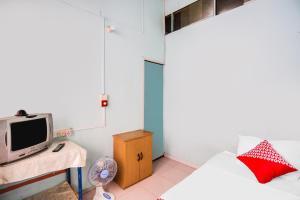 巴都安帕SPOT ON 92072 Restu Ibu Homestay Syariah的小房间设有床铺和电视