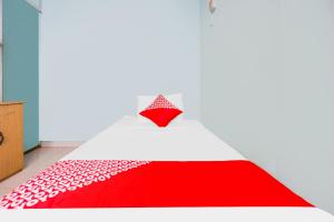 巴都安帕SPOT ON 92072 Restu Ibu Homestay Syariah的红色和白色的床,配有红色和白色的毯子