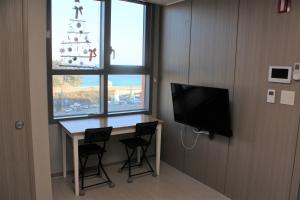 东海市Fine and You Ocean City的客房设有书桌、电视和窗户。