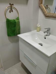 略夫雷加特河畔奥斯皮塔莱特Apartment Fira Bcn Camp Nou的浴室设有白色水槽和绿毛巾。