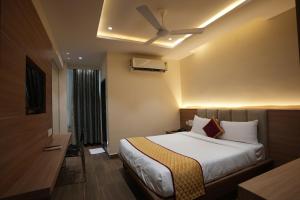 维杰亚瓦达HOTEL SUNRISE HOSPITALITY的酒店客房配有一张床和吊扇。