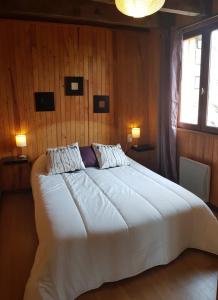 埃安Chalet La Campagnette的一间卧室配有一张带两盏灯的大型白色床。