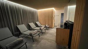 圣洛伦佐-迪塞巴托Residence Tantalus的客厅配有三把椅子和电视