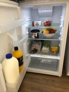 Marks PointLakeside Bungalow的配有一加仑牛奶和食物的开放式冰箱