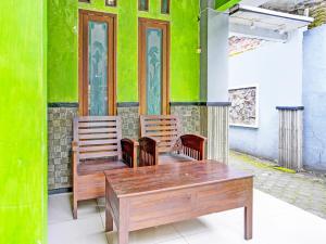 MojokertoOYO 92086 Fun Guesthouse Syariah的一张桌子和两把椅子以及绿色的墙壁