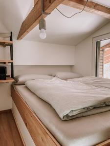 埃京Modernes Tinyhouse Trailer Cabins am Waldrand - mit Seezugang的一间卧室配有一张木架大床