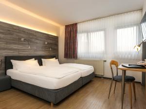 贝尔吉施格拉德巴赫Hotel & Wirtshaus Hansen的一间卧室配有一张床、一张桌子和一张书桌