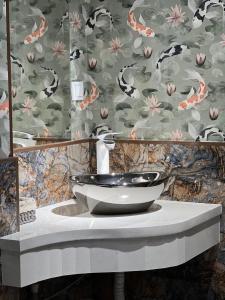 奇姆肯特WIND HOTEL的一间带水槽和花卉壁纸的浴室