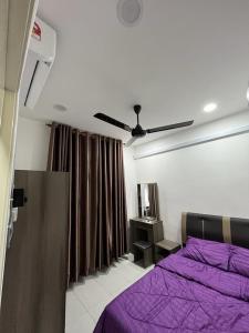 新邦安拨Surestay homestay的一间卧室配有紫色的床和吊扇