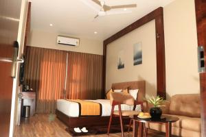 舍地Rudra Royals的一间卧室配有一张床、一把椅子和一张沙发