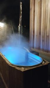 GesvesTiny house, sauna hot tub Gesves Namur Ardennes的蓝色浴缸,位于建筑的背景