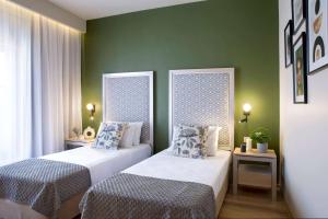 布加勒斯特Central Hotel, Trademark Collection by Wyndham的绿墙客房内的两张床