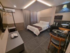 晋州市优碧酒店的酒店客房,配有一张床、一张桌子和椅子