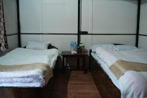 索拉哈Bamby Chilling House的客房设有两张床和一张带水瓶的桌子。