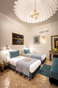 马拉喀什里亚德水疗巴伊亚萨拉姆酒店的一间卧室配有两张床和吊灯。
