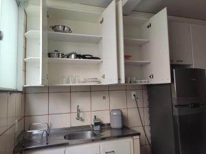 戈亚尼亚Apartamento 2 quartos Setor Sul的厨房配有白色橱柜、水槽和冰箱。
