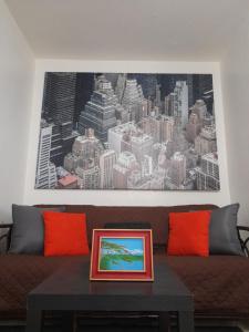 圣胡安Cozy Apartment across the San Juan Airport的客厅配有一张沙发,墙上挂有绘画作品