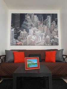 圣胡安Cozy Apartment across the San Juan Airport的客厅配有带橙色枕头的棕色沙发
