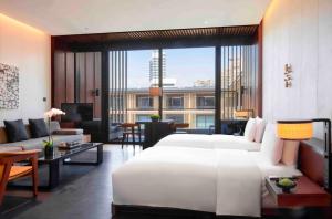 厦门厦门七尚酒店（奢享水天一色湾景）的一间带白色大床的卧室和一间客厅
