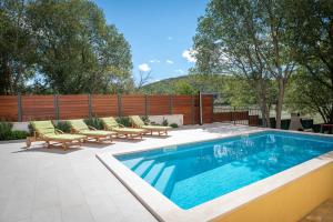 BiskoVilla Breeze - perfect getaway in untouched nature的围栏旁带躺椅的游泳池
