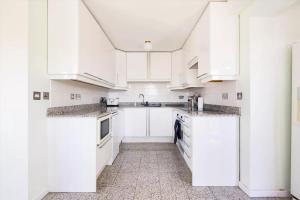 伦敦City Riverview Apartment with Parking的白色的厨房配有白色橱柜和电器