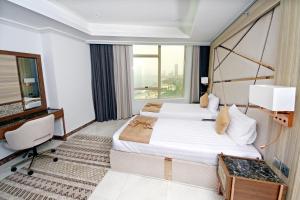 吉达Seafront Luxury Suites Jeddah Corniche的酒店客房设有两张床和窗户。