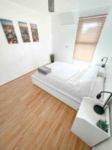 Hither GreenSpacious Two Bedroom flat的白色卧室配有床和书桌