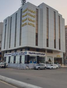 吉达المهيدب للوحدات السكنيه - البوادي的一座大型建筑,前面有汽车停放