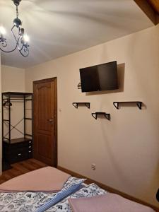 布科维纳-塔钱斯卡Willa Wschód Słońca的卧室配有一张床,墙上配有电视。