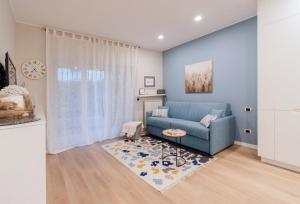 圣雷莫Ariston & Casinò - Appartamento con Giardino e Garage的客厅配有蓝色的沙发和地毯。