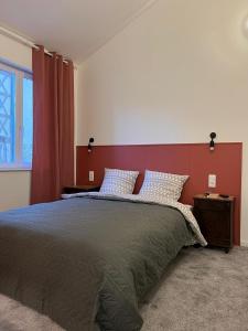 里摩日THEIA Hotel & Suites - Limoges Centre的一间卧室配有一张大床和红色床头板